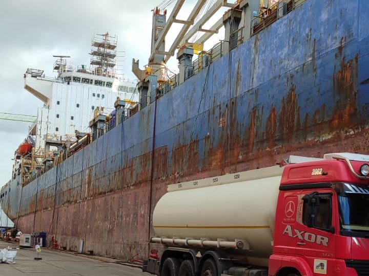 Rıhtımda yük gemisinin yanına yanaşmış su tankeri